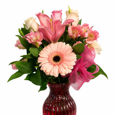 Pink and cream mixed bouquet in a red glass vase