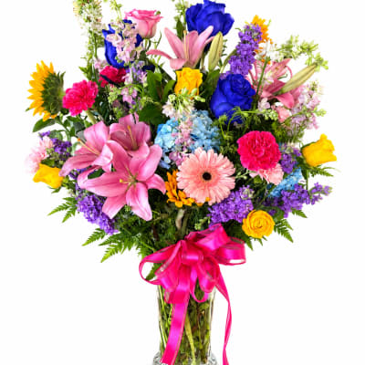 Colorful mixed bouquet in a clear glass vase with a pink ribbon
