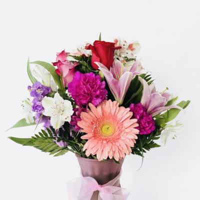 Mixed bouquet in a pink vase with a ribbon bow