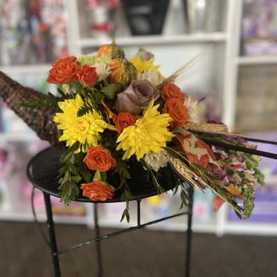 Bouquet of orange and yellow flowers with decorative gourds