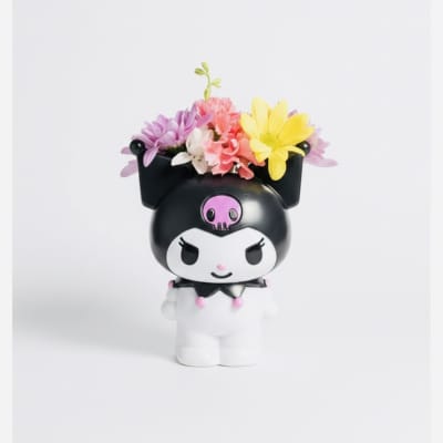 Small character figurine topped with colorful flowers
