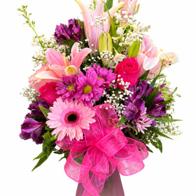 Pink and purple mixed bouquet in a vase with a bright pink ribbon