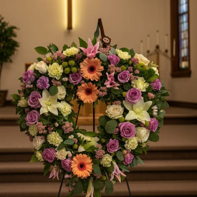 Heart-shaped floral wreath on an easel in a church