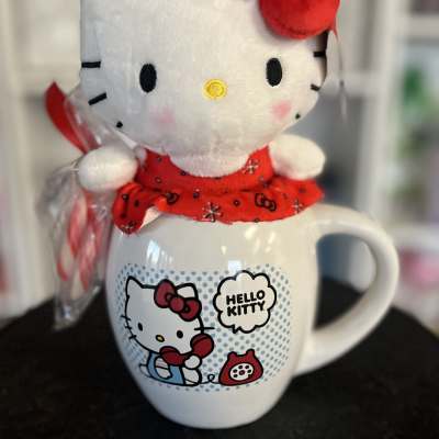 Hello Kitty plush sitting on a Hello Kitty mug