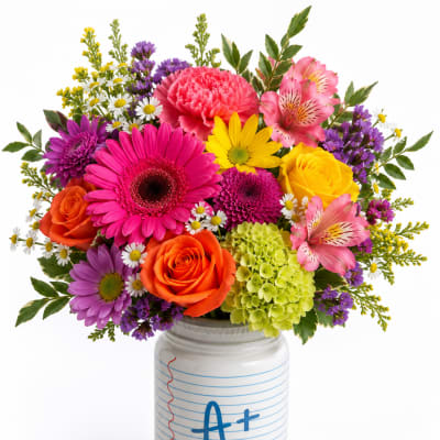 Colorful mixed bouquet in a white jar vase with an A+ design