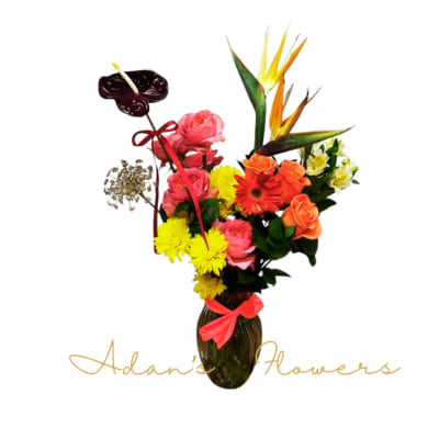 Mixed bouquet in a dark vase with roses, daisies, and tropical blooms