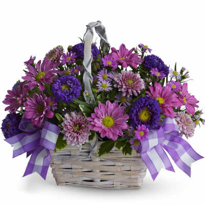 Purple and pink daisy bouquet in a wicker basket with ribbon bows