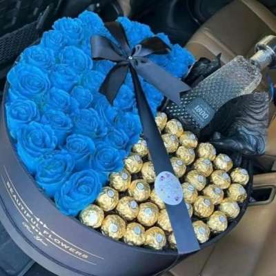 Blue rose bouquet with Ferrero Rocher chocolates in a round box