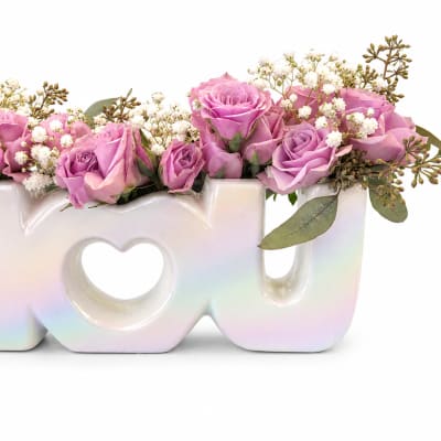 Pink roses in a white iridescent LOVE vase