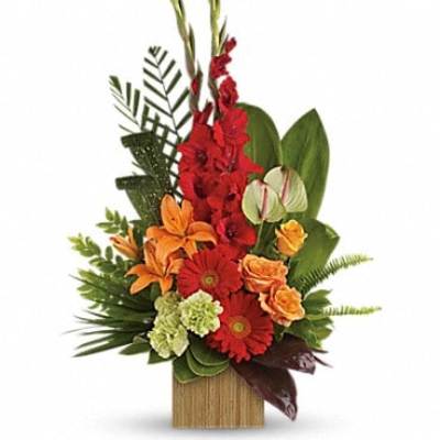 Tropical flower arrangement with red, orange, and green blooms in a wooden container