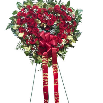 Heart-shaped red rose standing spray with ribbons on an easel
