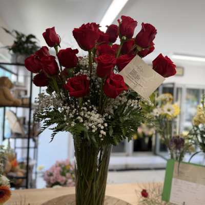 Tall vase arrangement of red roses with white baby's breath