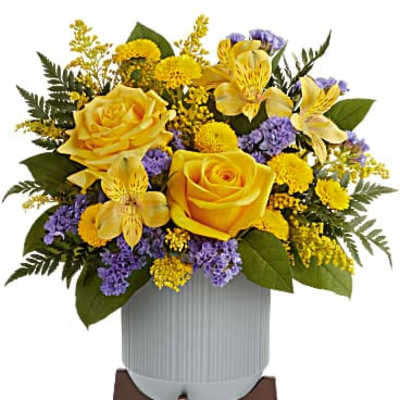 Yellow roses and purple flowers arranged in a white vase