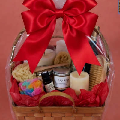 Gift basket with bath items, candles, and a large red bow