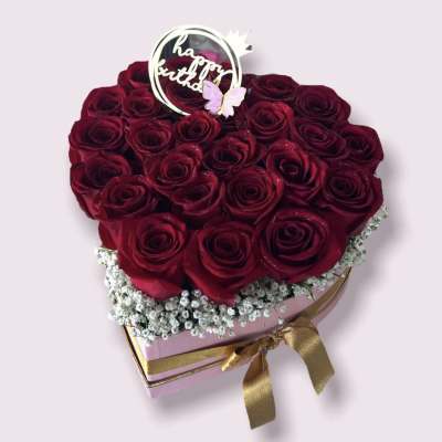 Heart-shaped box of red roses with a birthday topper and gold ribbon