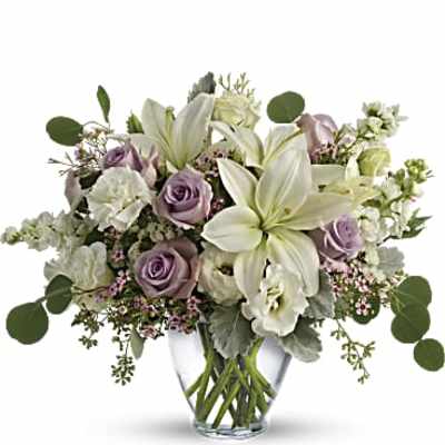 Lavender roses and white lilies in a clear glass vase