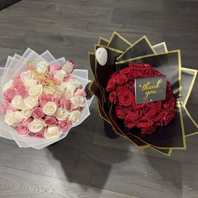 Two rose bouquets, one pink and white and one red, wrapped in decorative paper