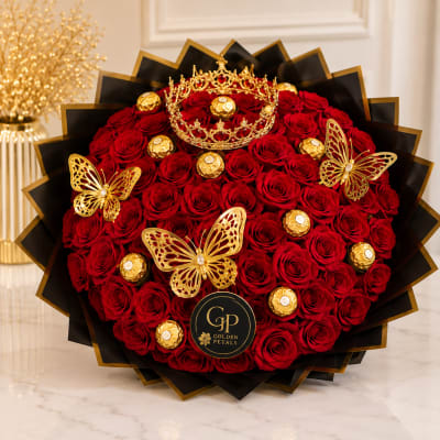 Round bouquet of red roses with gold butterfly accents and chocolates