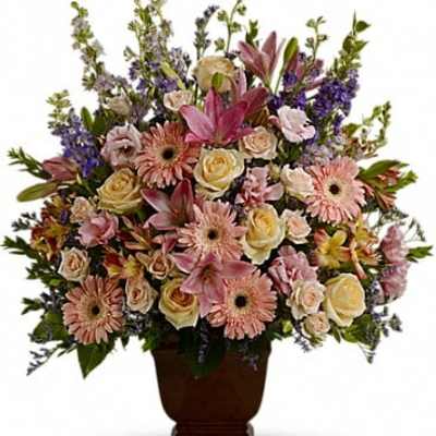 Large mixed flower arrangement in a dark urn vase