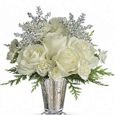 White roses and glittery silver sprays in a silver vase