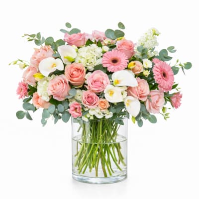 Pink roses and white calla lilies in a clear glass vase