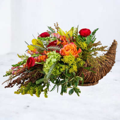 Colorful flower arrangement in a woven basket with red and orange blooms