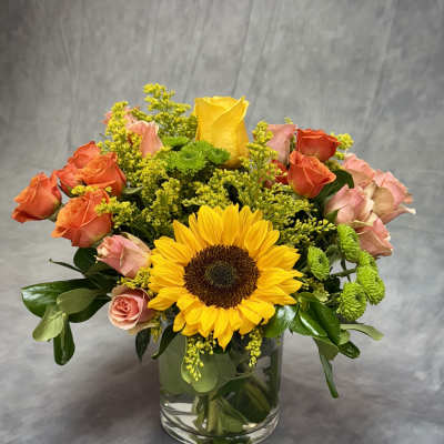Bouquet of sunflowers and roses in a clear glass vase