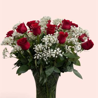Red roses and white baby's breath in a clear glass vase