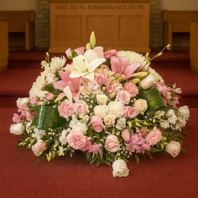 Large pink and white funeral spray in a church sanctuary