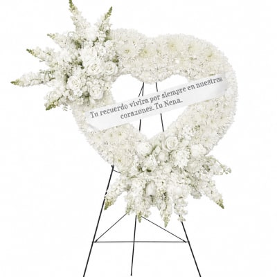 White floral heart wreath on a stand with a memorial ribbon