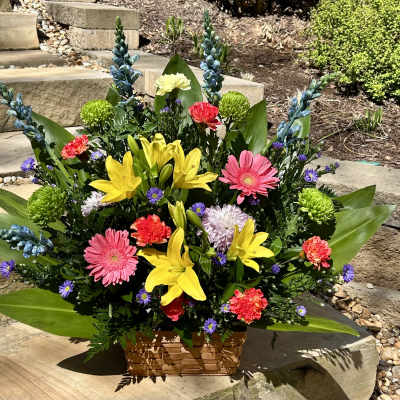 Colorful mixed flower arrangement in a woven basket