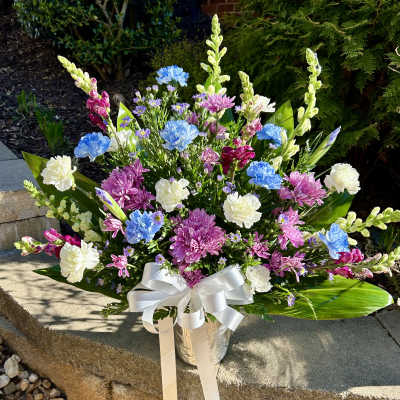 Colorful mixed bouquet in a silver vase with a white ribbon
