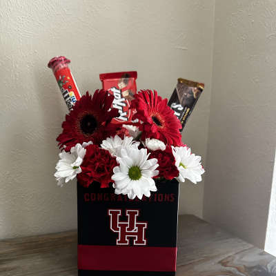 Red and white daisy arrangement in a black gift box with candy bars