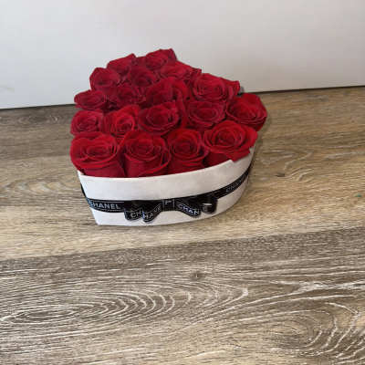 Heart-shaped box filled with red roses and a black ribbon