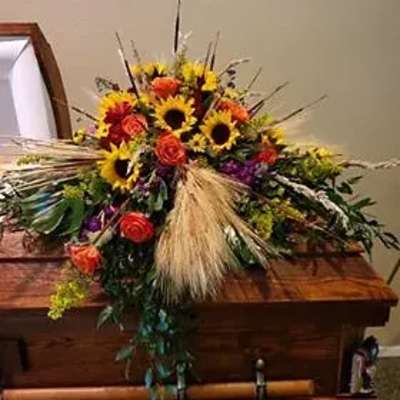 Large casket spray with sunflowers and orange roses