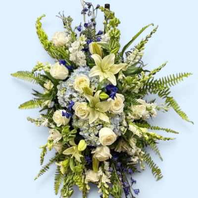 Standing floral spray with white lilies, roses, and blue flowers