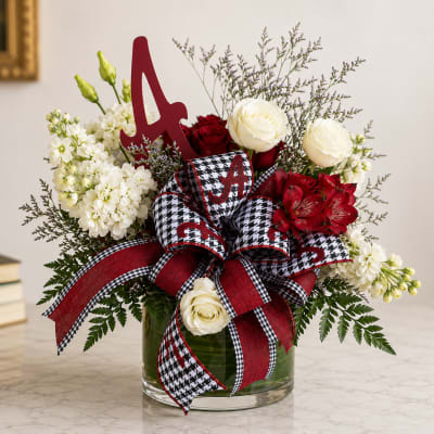 Red and white floral arrangement in a glass vase with a large ribbon and letter A