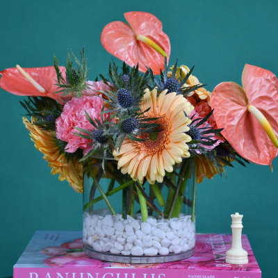 Mixed bouquet in a glass vase with pink anthuriums and peach gerberas