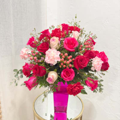 Pink and red rose bouquet in a bright pink vase