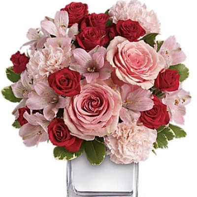 Pink and red rose bouquet in a clear square vase