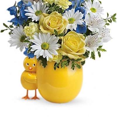 Yellow vase with mixed flowers and a small chick figurine