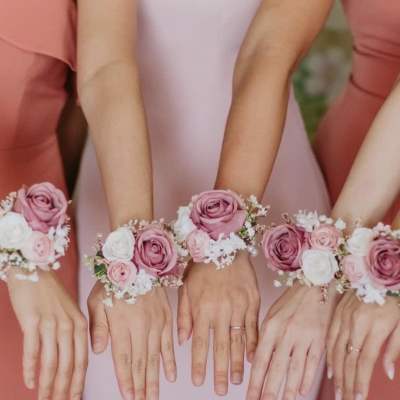 Bridesmaids wearing pink rose wrist corsages