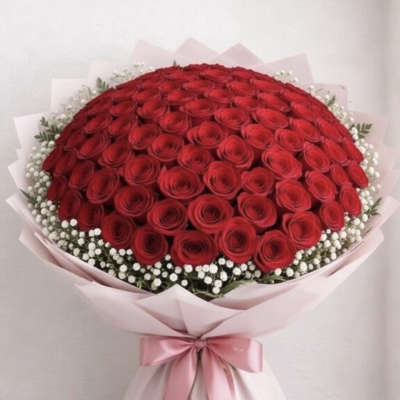Large bouquet of red roses wrapped in pink paper with a pink ribbon