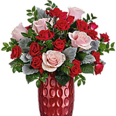 Red and pale pink roses arranged in a red vase