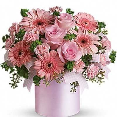 Pink roses and gerbera daisies in a pink hatbox