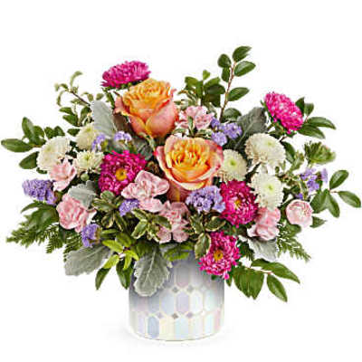 Mixed bouquet of pink, orange, white, and purple flowers in a patterned vase