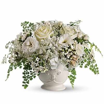 White roses and calla lilies in a white urn vase