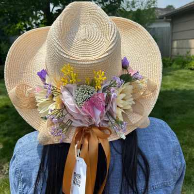Straw hat decorated with pastel flowers and ribbon