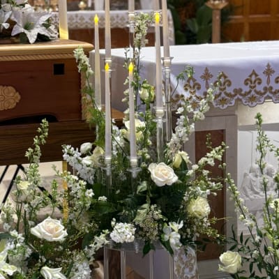 White roses and candles arranged in a wedding altar display