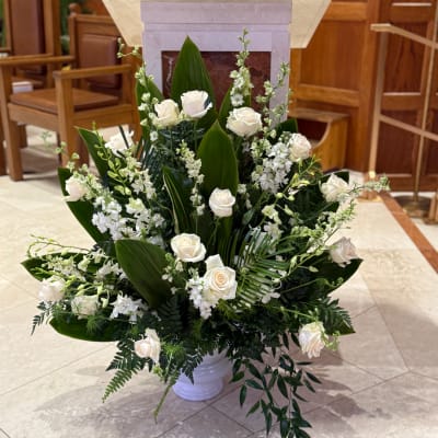 White roses and white flowers arranged in a white vase